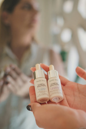 a woman holding two bottles of skin care products