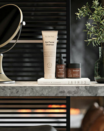 Skincare products arranged on a shelf near a mirror.
