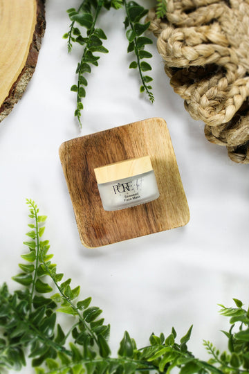 A small jar of cream on a wooden coaster.