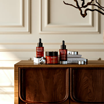 Skincare products displayed on a wooden dresser.